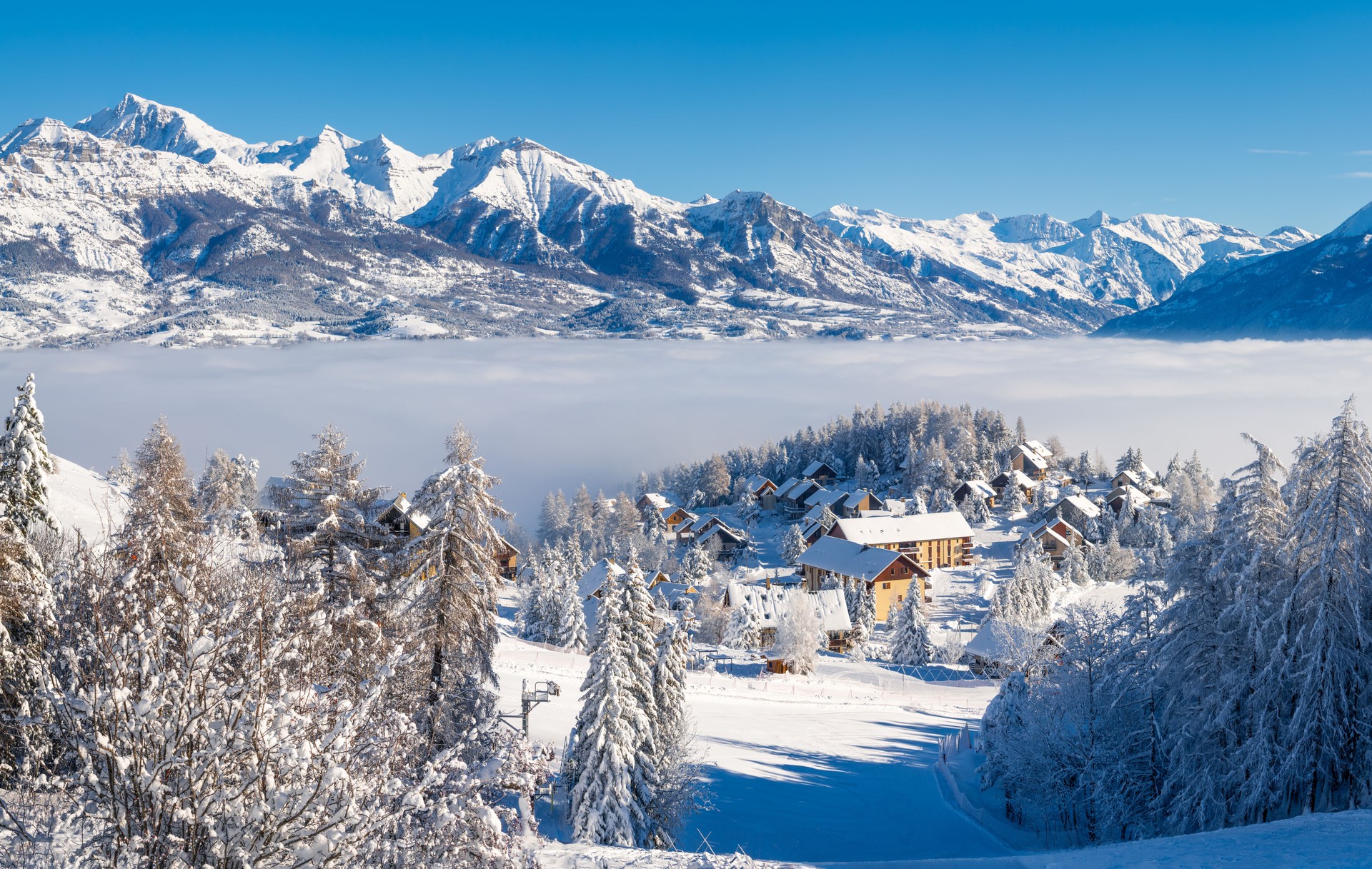 Laye winter ski resort in Champsaur Valley covered in fresh snow with view of the mountains of the Ecrins National Park. French Alps. Hautes-Alpes, France